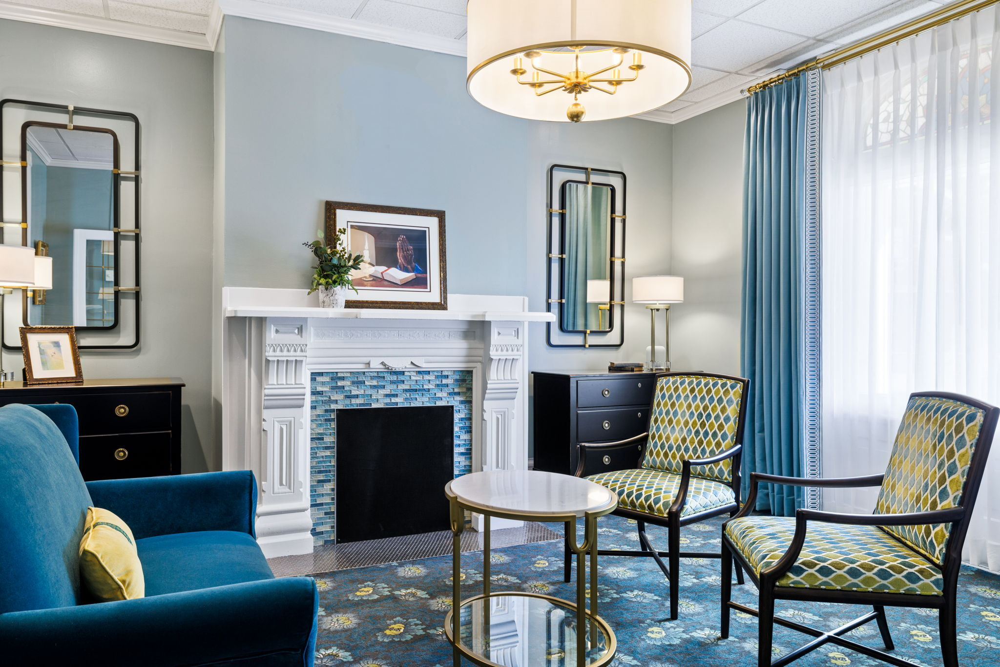 Coston Funeral Homes sitting room with a white fireplace and blue furnishings